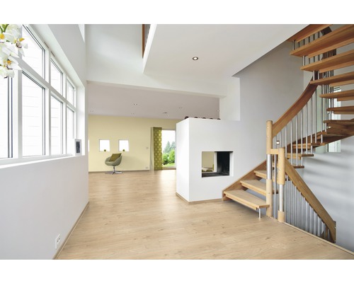 Lichte ruimte met houten trap, laminaatvloer en zithoek