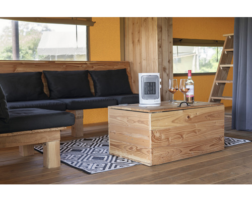 Interieur van een tent met houten meubels, een kachel en een fles wijn met glazen