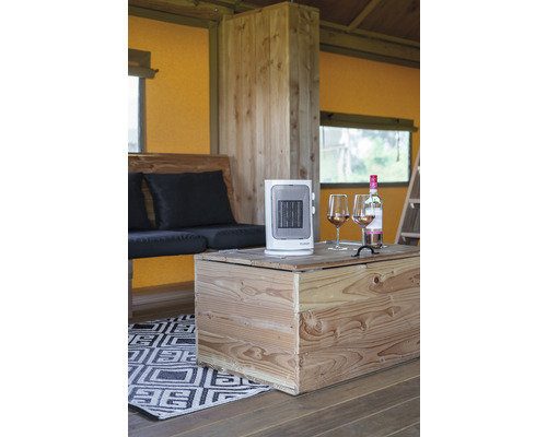 Interieur met houten meubels, een draagbare kachel en twee glazen wijn op een houten tafel