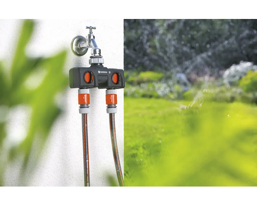 Gardena waterverdeler op een kraan met twee aangesloten tuinslangen.