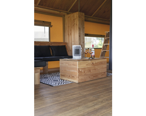 Interieur van een tent met houten meubels, kachel en drankjes.