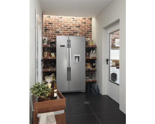 Keuken met side-by-side koelkast, planken, bakstenen muur en zwarte tegelvloer