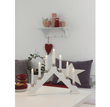 Witte houten adventskandelaar met zeven LED-kaarsen op een tafel met decoraties