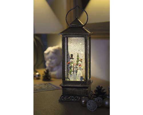 Decoratieve lantaarn met sneeuwpopfamilie en sneeuwglitter voor een kerstsfeer