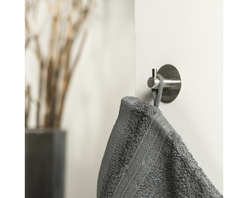 Handdoekhaak met grijze handdoek aan een muur