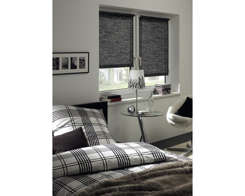 Slaapkamer met bed, nachtkastje en raam met rolgordijn