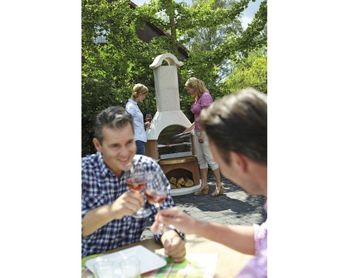 Scène van een barbecue in de tuin met een stenen barbecue en feestende mensen