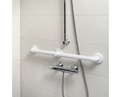 Foto van een badkamer met handgreep, douchestang en kraan