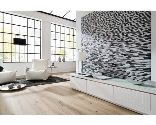 Lichte woonkamer met parketvloer, mozaïekwand en grote ramen