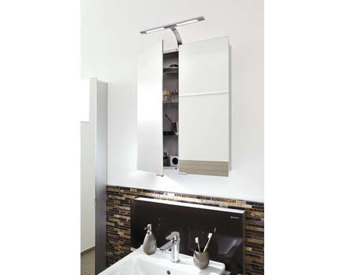 Spiegelkast met verlichting boven een wastafel in de badkamer.