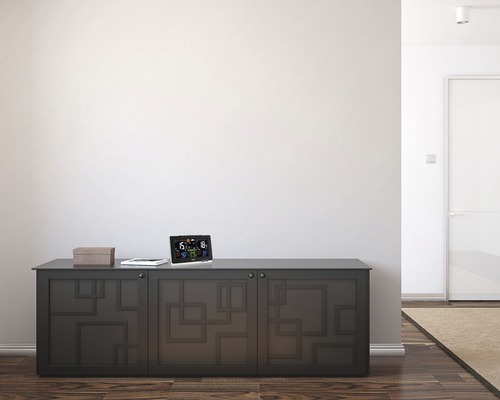 Weerstation op een dressoir in een lichte ruimte.