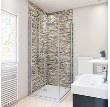 Badkamer met douchecabine, wastafel en toilet voor een stenen muur