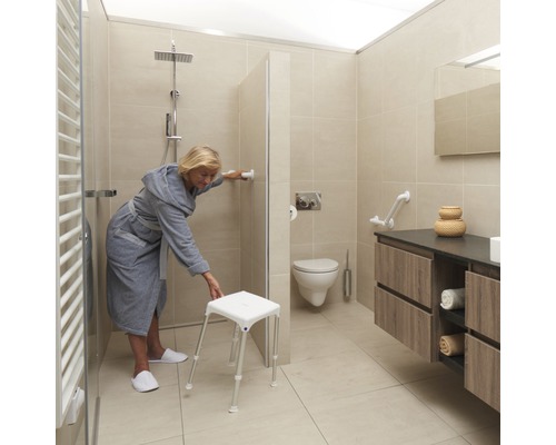 Lichte badkamer met douche, toilet, wastafel en douchekruk voor senioren