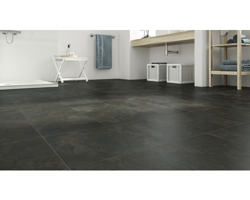 Badkamer met donkere vloertegels, wastafel en douche.