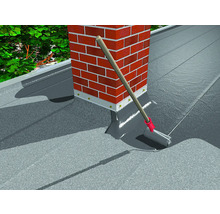 Dakbedekking aanbrengen met een roller bij een schoorsteen