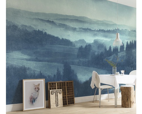 Woonkamer met fotobehang van een berglandschap, eettafel en decoratie