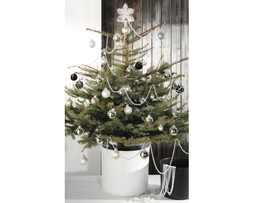 Versierde kerstboom in pot met kerstballen en slingers