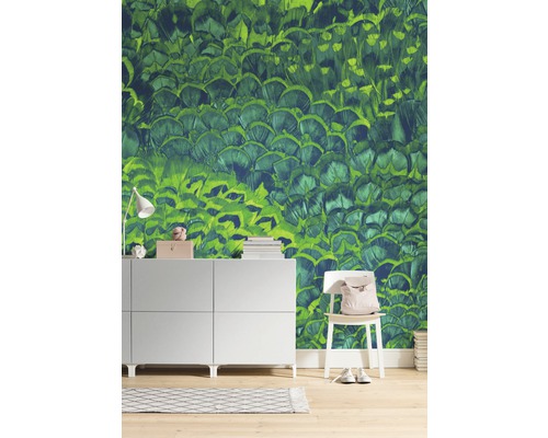 Woonkamer met groen behang met verenontwerp, dressoir en stoel