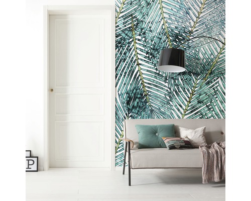 Woonkamer met deur, bank en wandbehang met palmenbladmotief