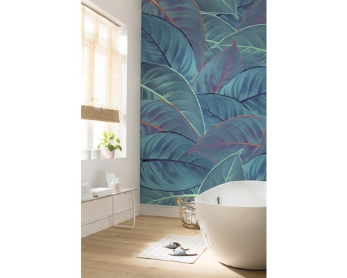 Badkamer met bad, raam en wandbehang met bladerenmotief