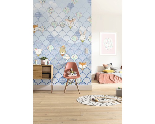 Kinderkamer met behang in schubdesign en dierenmotieven, ingericht met meubels en speelgoed.