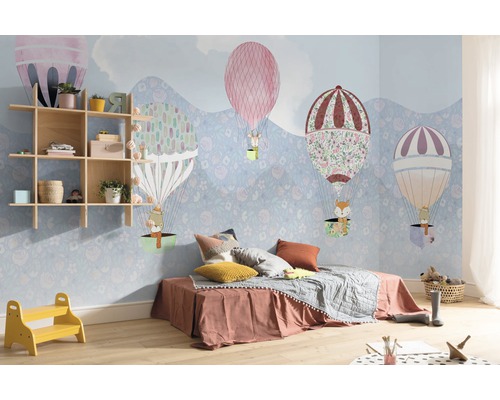 Kinderkamer met behang met luchtballonnen, houten rek en laag bed