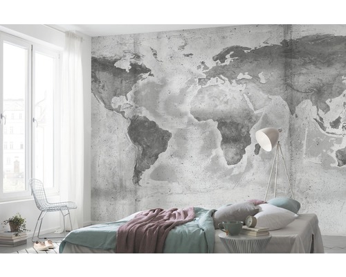 Slaapkamer met fotobehang van een wereldkaart, bed en lamp