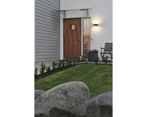 Gevel met houten deur, glazen luifel en buitenlamp