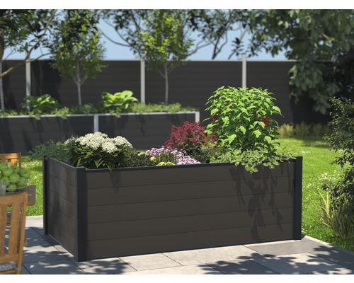 Vierkante verhoogde tuinbak van houtcomposiet in de tuin met planten