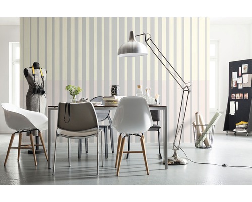 Woonkamer met eettafel, stoelen, vloerlamp en gestreept behang voor een lichte, georganiseerde sfeer.