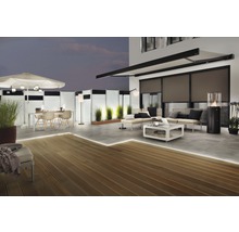 Terras met houten vlonder, zonnescherm, privacyscherm, tuinmeubelen en verlichting