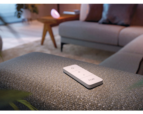 Philips Hue afstandsbediening op een kruk in een woonkamer