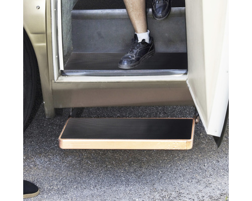 Uitschuifbare opstap op een camper met persoon die de treden gebruikt.