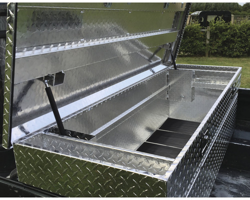 Geopende gereedschapskist van aluminium met een ruitjespatroon op een laadvloer