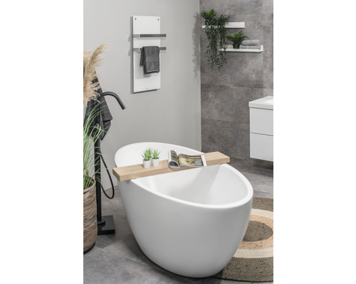 Badkamer met vrijstaand bad, handdoekradiator en decoratieve elementen voor een ontspannen sfeer