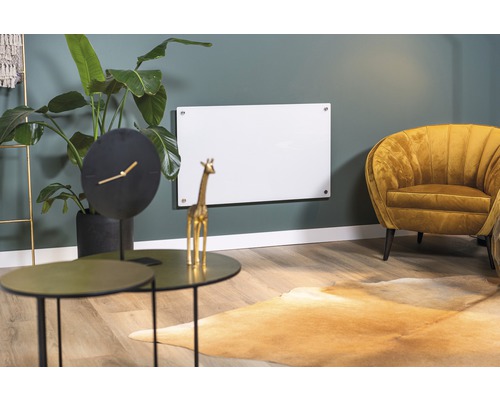 Woonkamer met infraroodverwarming aan de muur, tafel, klok en fauteuil