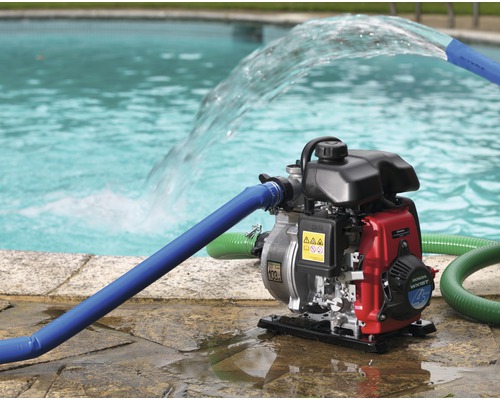 Waterpomp met slangen bij zwembad