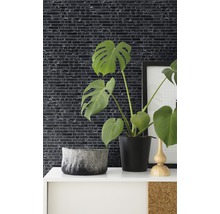 Decoratieve wanddecoratie met mozaïektegels in een kamer met kamerplanten en decoratieve elementen.