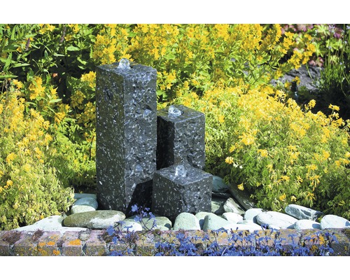 Decoratieve tuinfontein van natuursteen met drie zuilen en waterspel