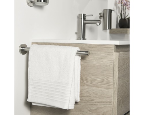 Handdoekhouder met witte handdoek aan wastafel