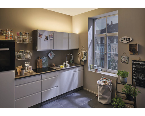 Lichte keuken met inbouwkasten, gootsteen, raam en decoraties