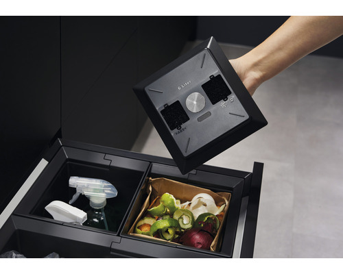 Afvalscheidingssysteem met verschillende bakken voor afvalsortering en een 6 liter filterdeksel, die in de hand wordt gehouden.