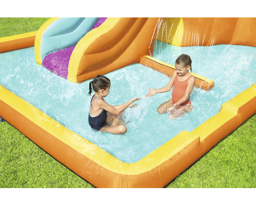 Opblaasbare waterglijbaan met zwembad en spelende kinderen