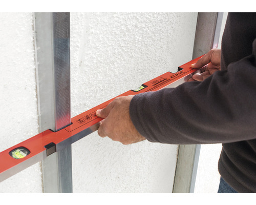 Vakman met waterpas op metalen profiel