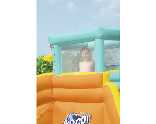 Opblaasbare waterglijbaan met spelend kind in kijkvenster