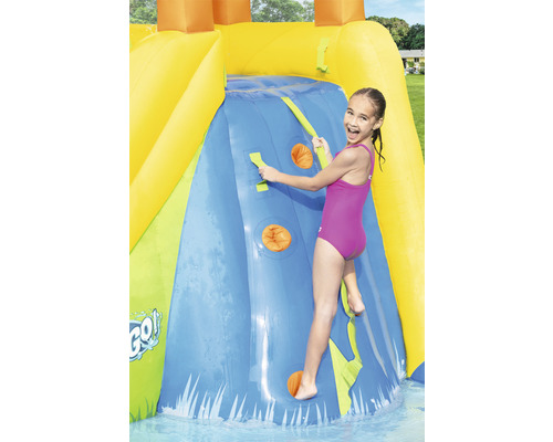 Meisje klimt op een opblaasbare waterglijbaan met klimwand