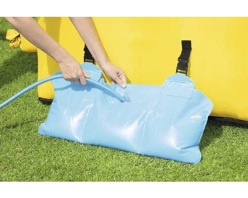 Persoon vult waterzak voor het verzwaren van een springkussen met een waterslang