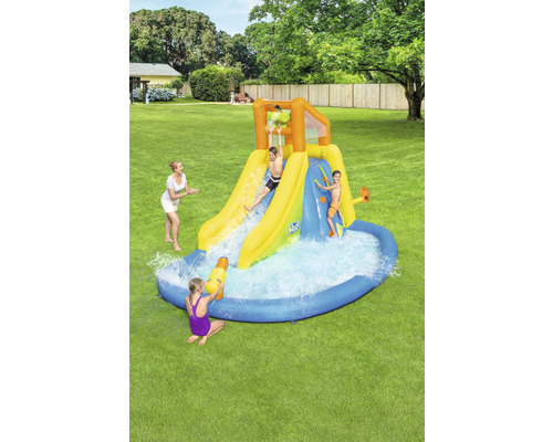 Opblaasbare waterglijbaan met zwembad en spelende kinderen in de tuin