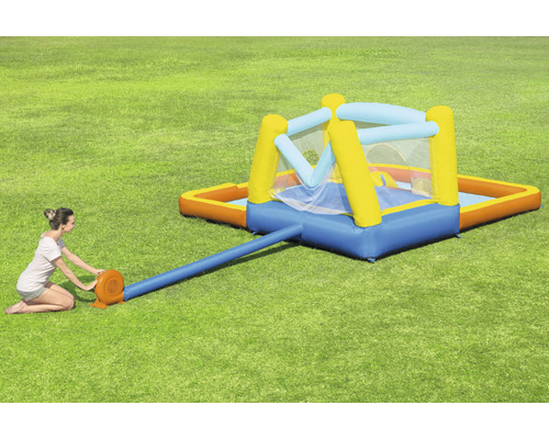 Opblaasbaar springkussen met zwembad in de tuin met vrouw die het opblaast.