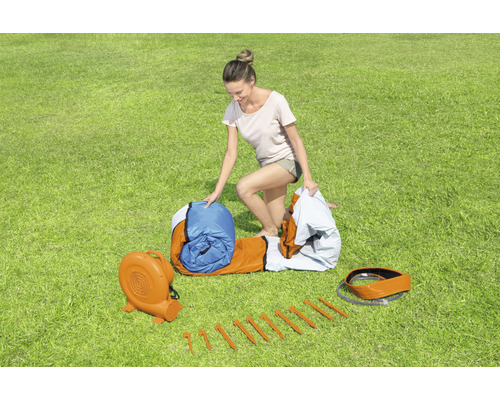 Opblaasbaar springkussen met ventilator, haringen en dame op gazon